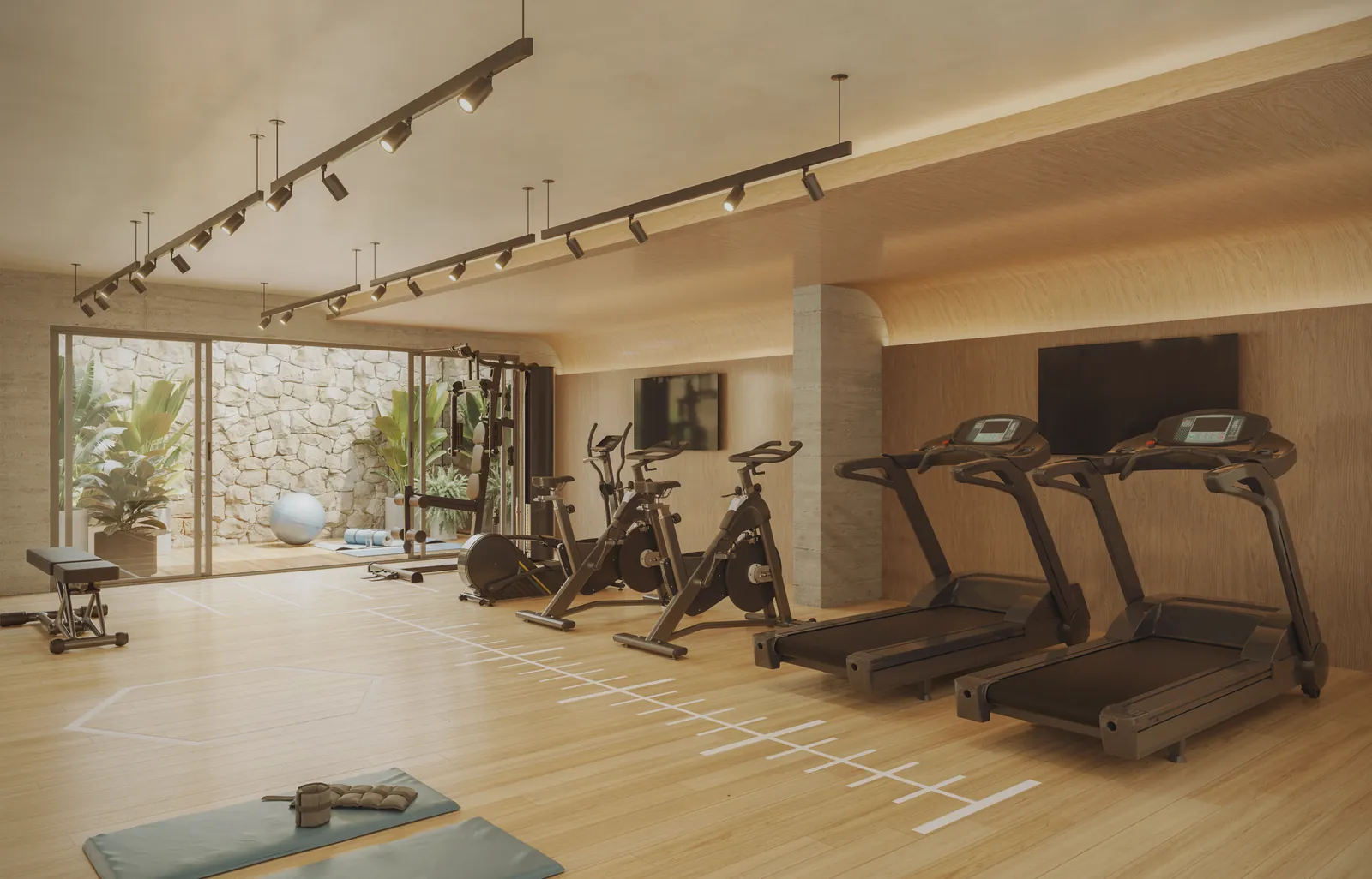 Academia com esteiras e bicicletas de frente para um jardim vertical