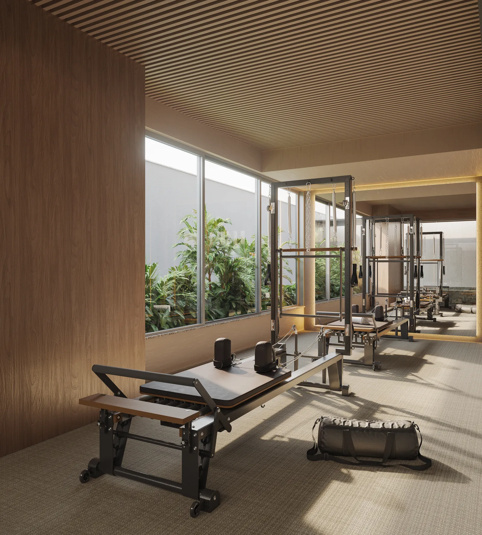 Sala de pilates com aparelhos e janelas para a vegetação