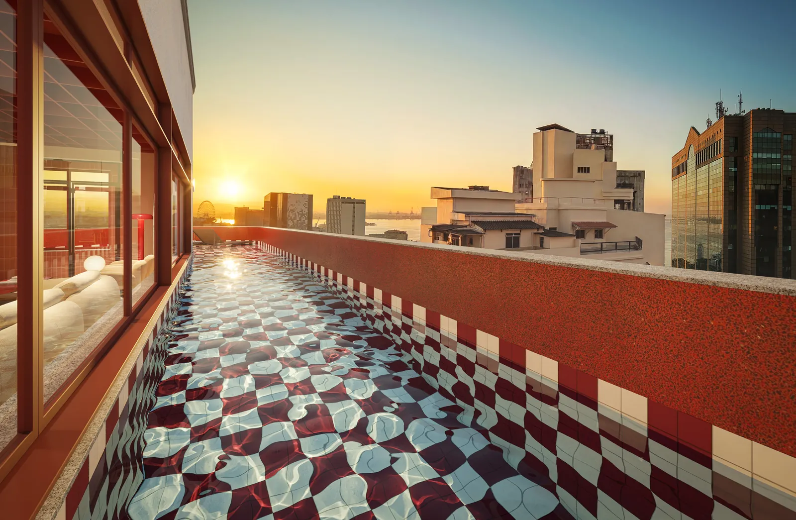 Piscina do rooftop com piso xadrez vermelho e branco, ao pôr do sol