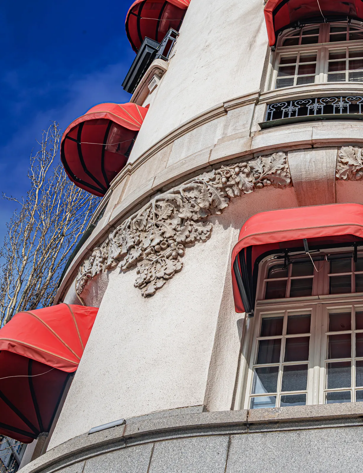 Detalhe da fachada branca com toldos vermelhos e ornamentos