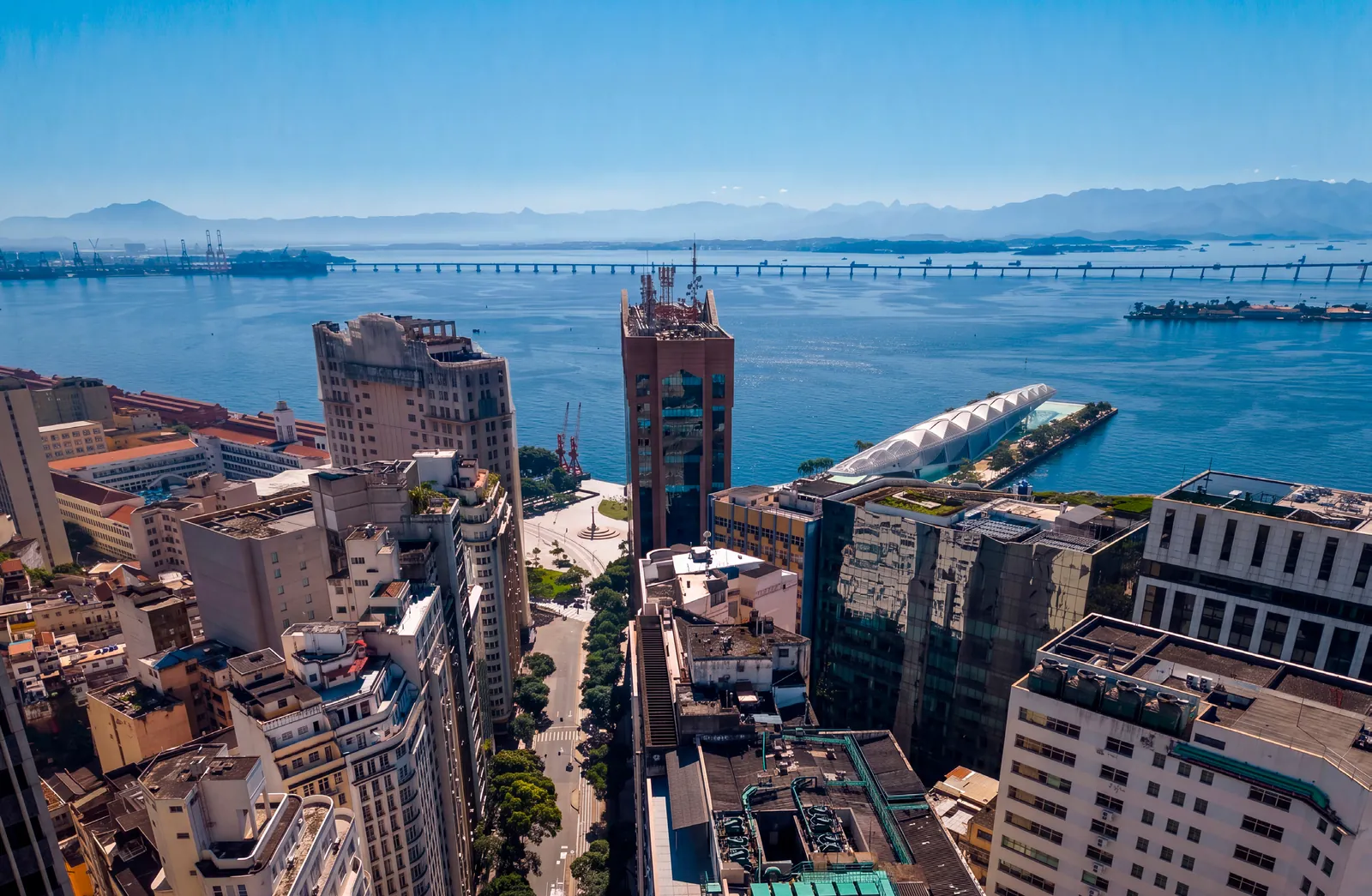 Vista aérea do Centro do Rio com a Baía de Guanabara e a Ponte Rio-Niterói ao fundo