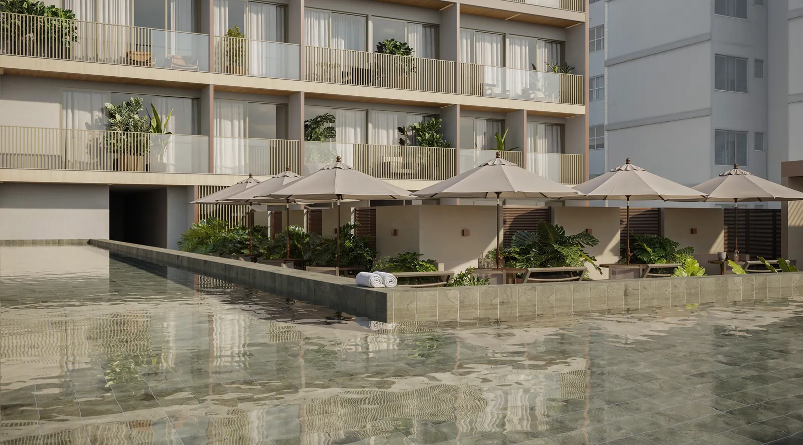 Piscina com raia, espreguiçadeiras e guarda-sóis entre os prédios