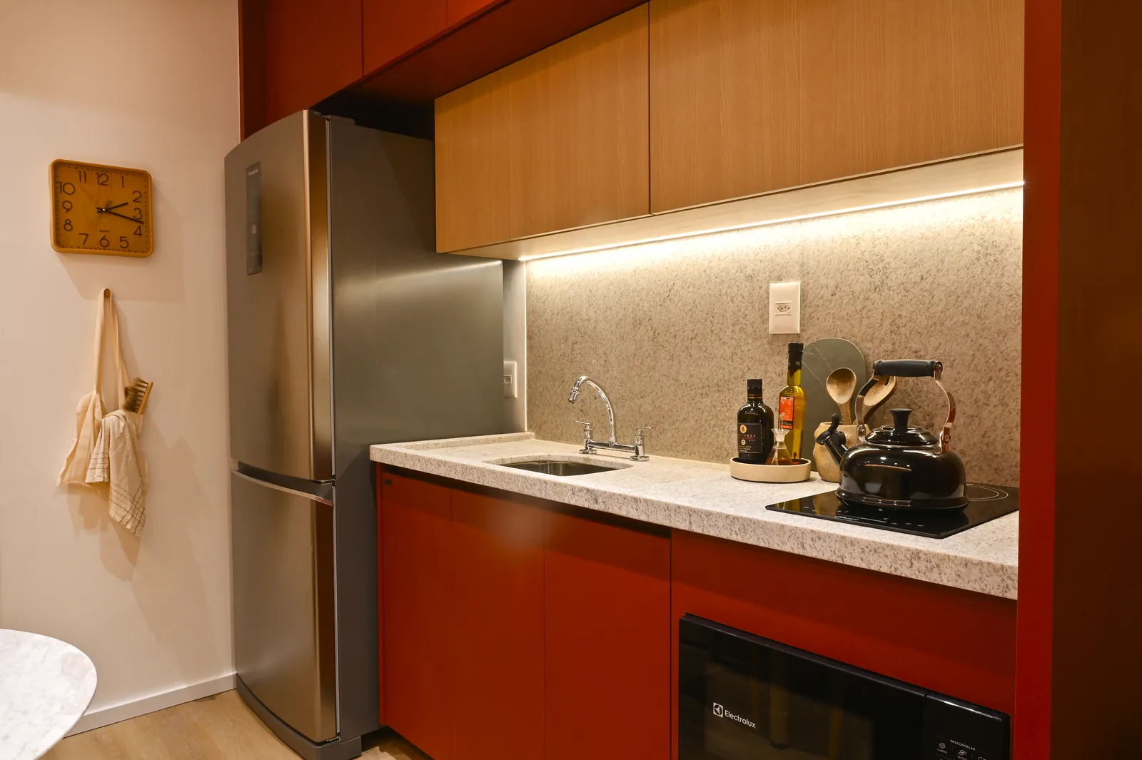 Bancada da cozinha com cooktop e armários de madeira clara