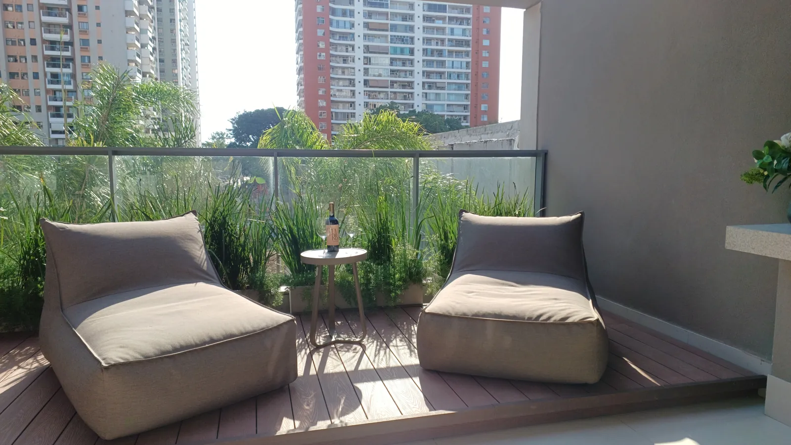 Varanda com poltronas e plantas, voltada para as árvores