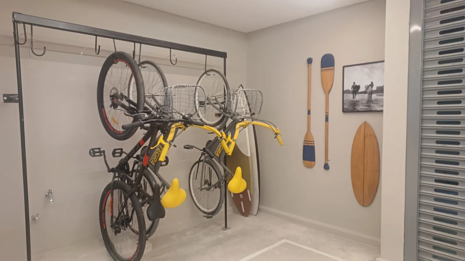 Garagem privativa com bicicletas e pranchas penduradas na parede