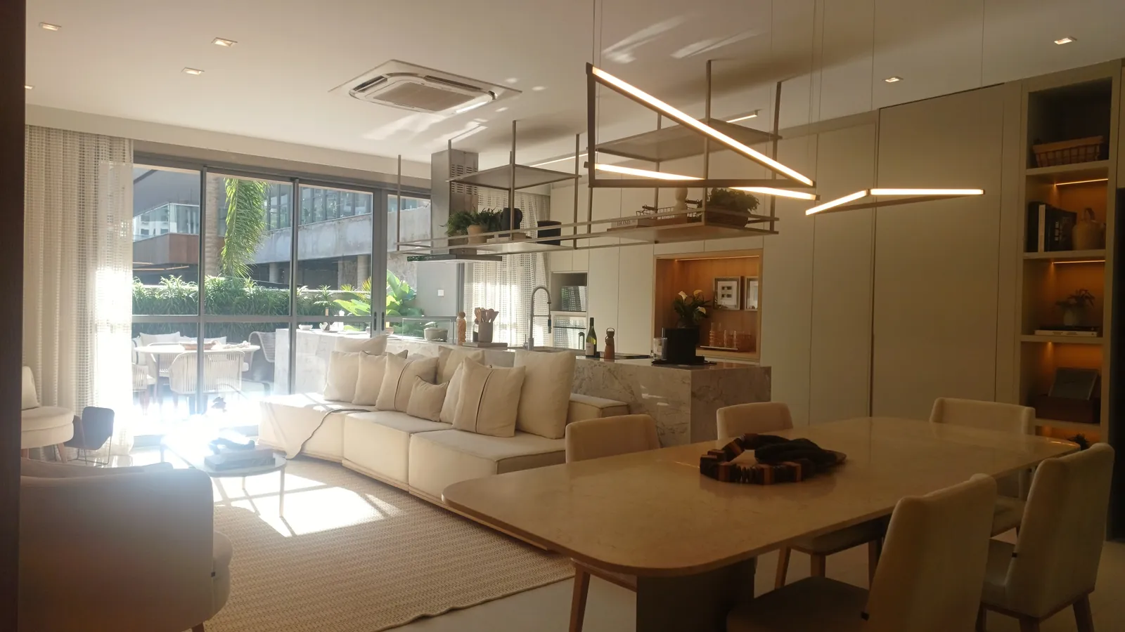 Sala e jantar da casa decorada, com luminária pendente e vista para o jardim