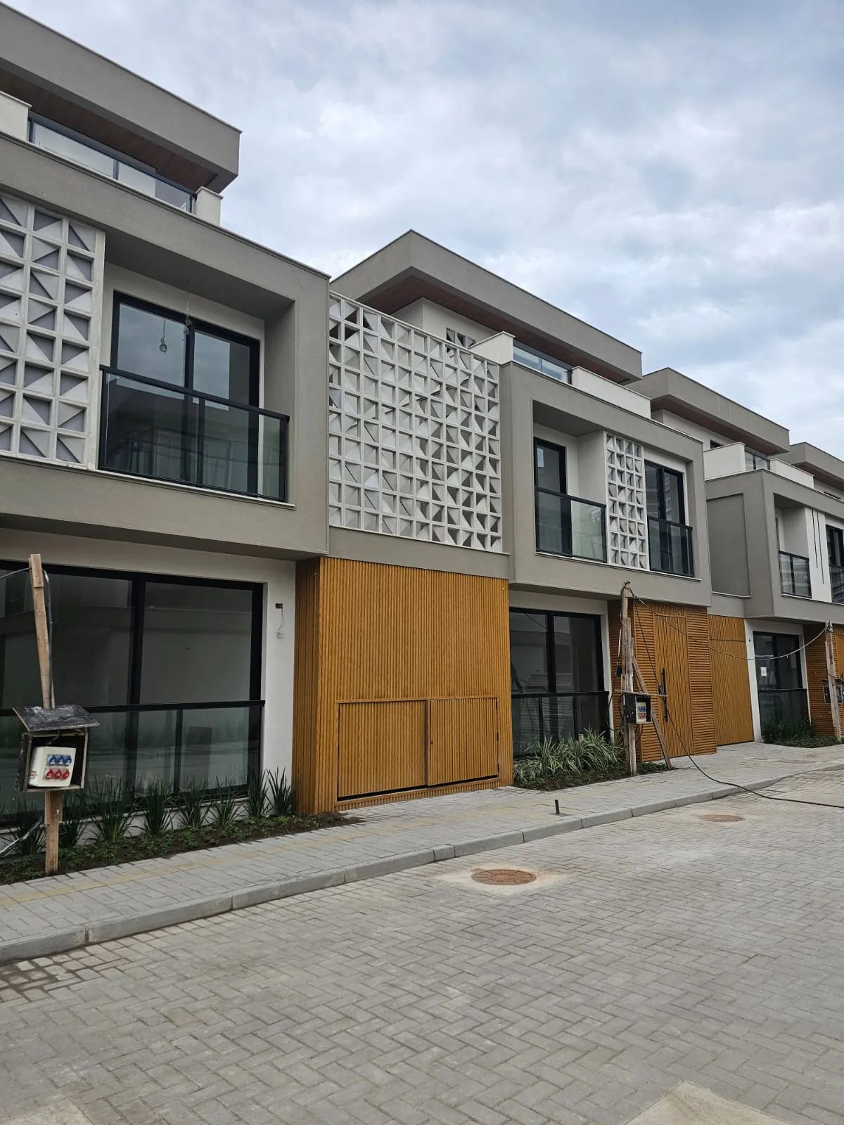 Casas prontas do Art Design lado a lado, com portões de madeira