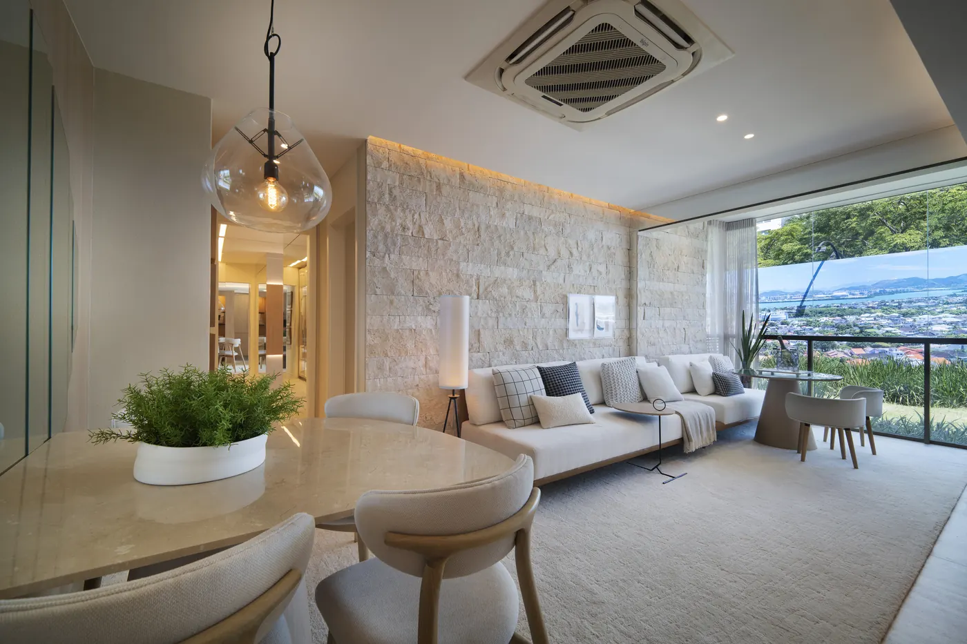 Sala de jantar e estar do decorado de 2 suítes, com parede de pedra