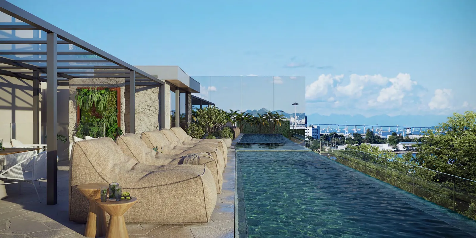A piscina de borda infinita do Glória Del'Art, com pufes e vista para a Baía