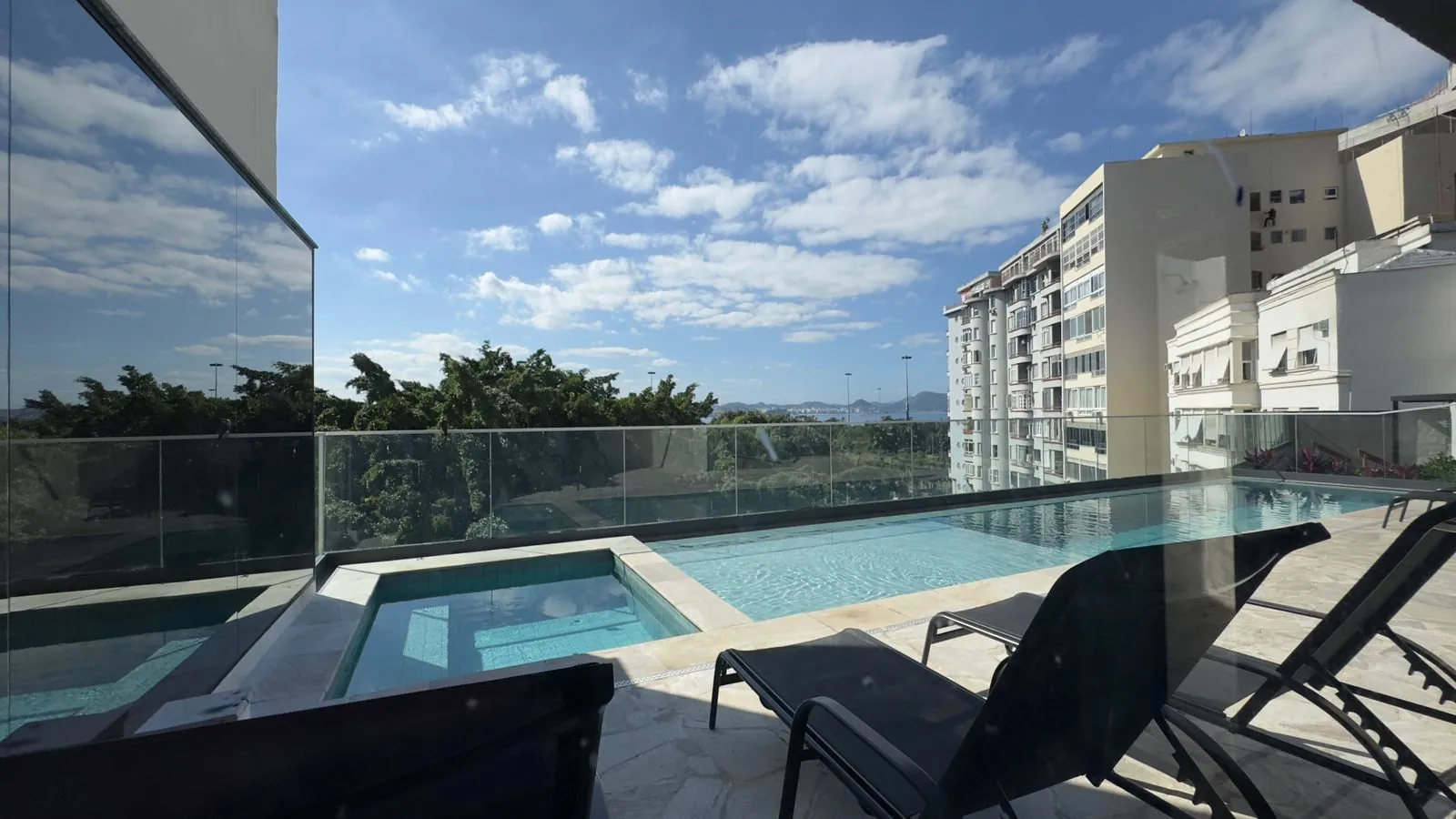 Foto real da piscina do Glória Del'Art, com espreguiçadeiras