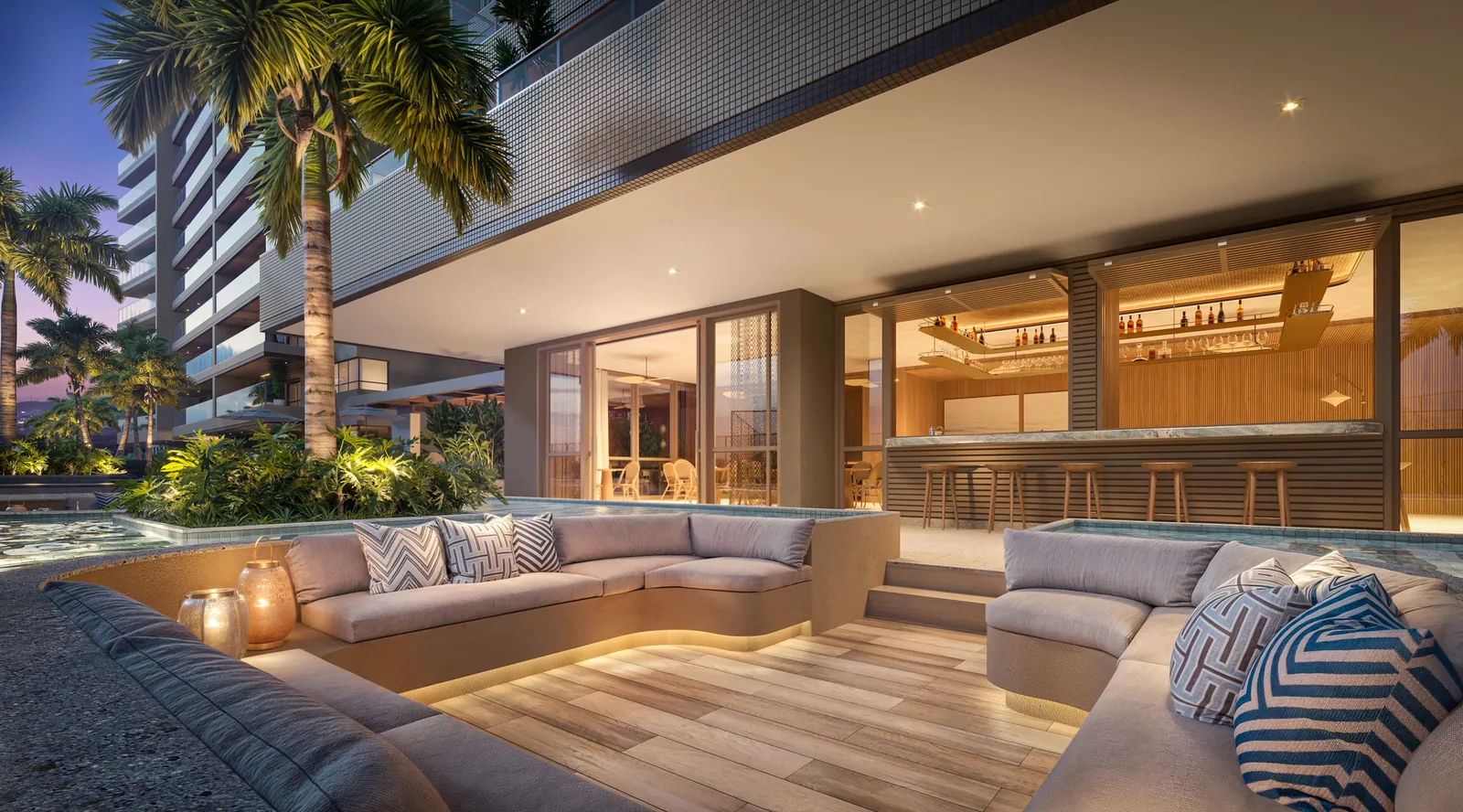 Lounge rebaixado com sofás em volta, junto à piscina, ao anoitecer