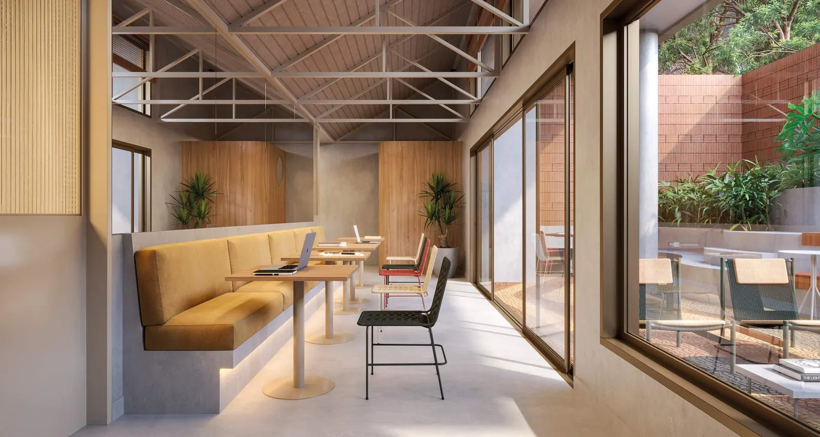 Coworking com bancadas, cadeiras e janelas amplas