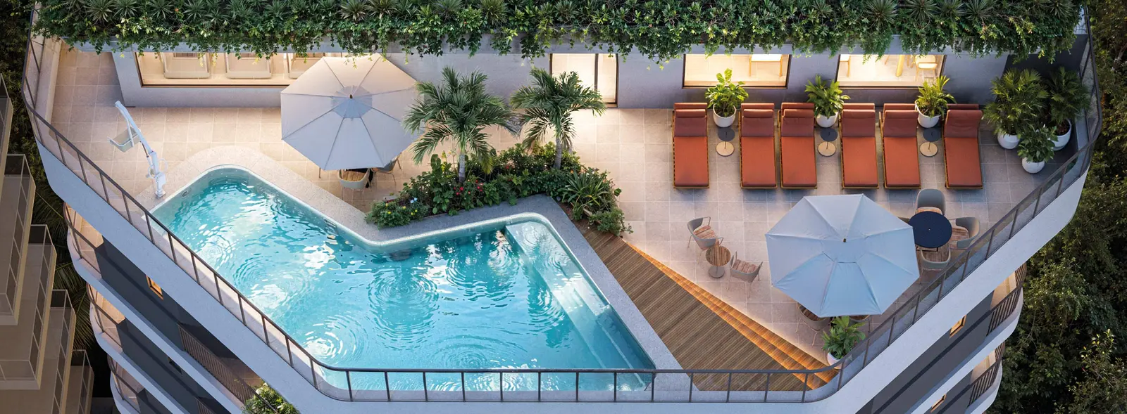Vista aérea do rooftop, com a piscina de desenho irregular, espreguiçadeiras e ombrelones