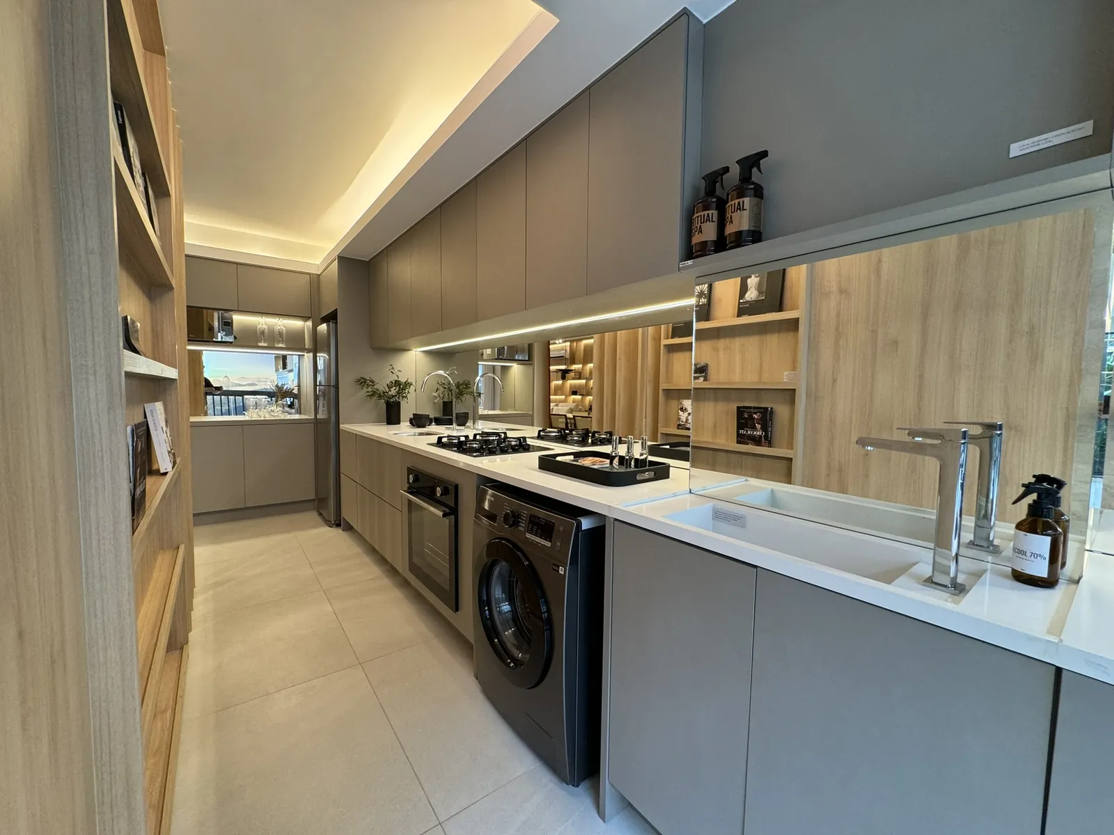 Foto da cozinha do apartamento decorado do H.U.M, com armários de madeira e máquina de lavar