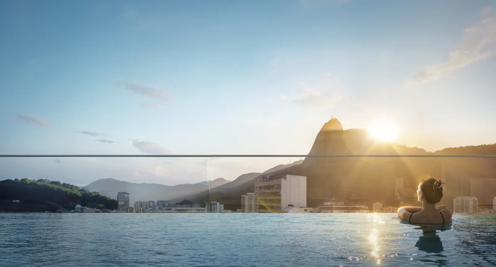 A piscina de borda infinita no topo do prédio, com o Cristo e os morros ao fundo