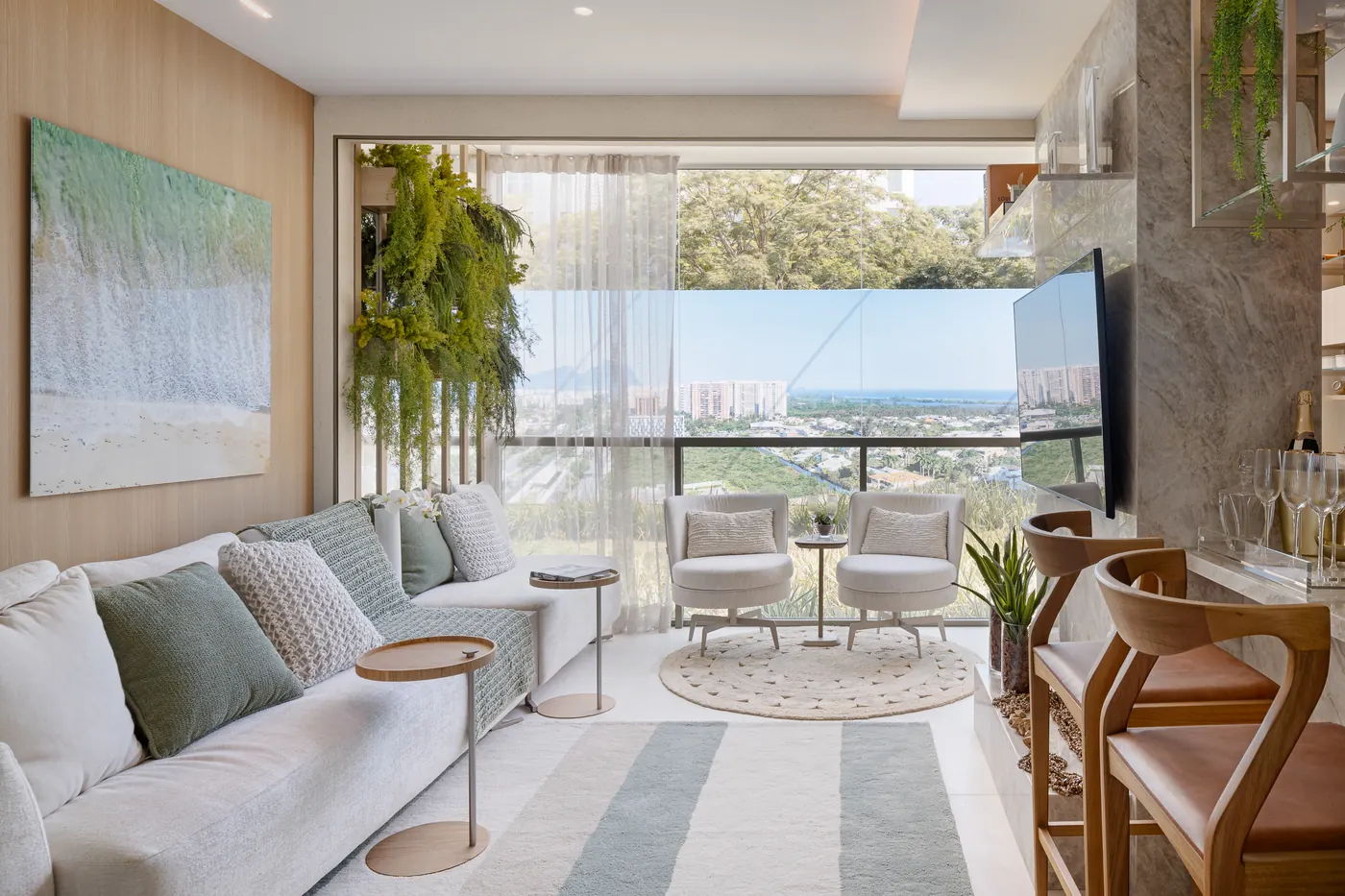 Sala e varanda do decorado de 2 quartos, com sofá claro e vista para o verde