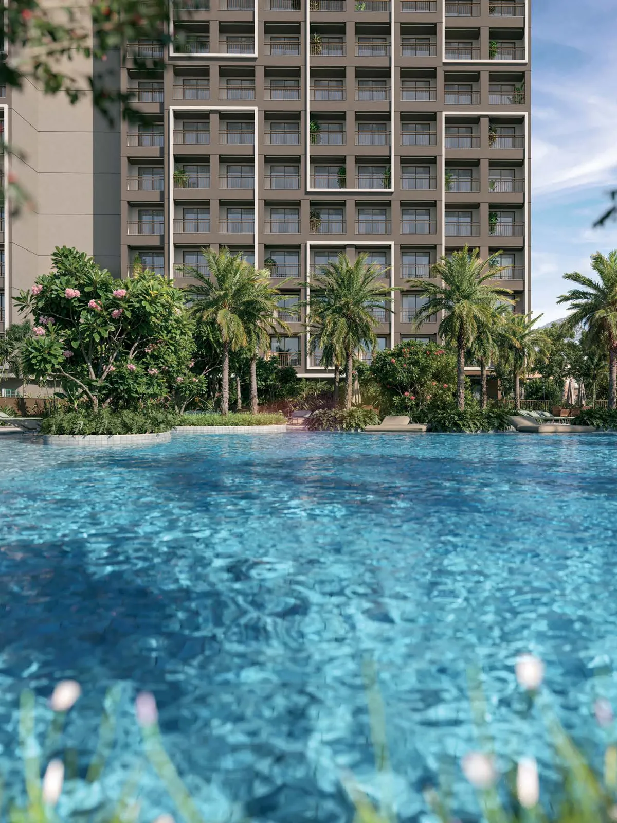 A piscina do In The Park entre palmeiras, com a torre Park ao fundo
