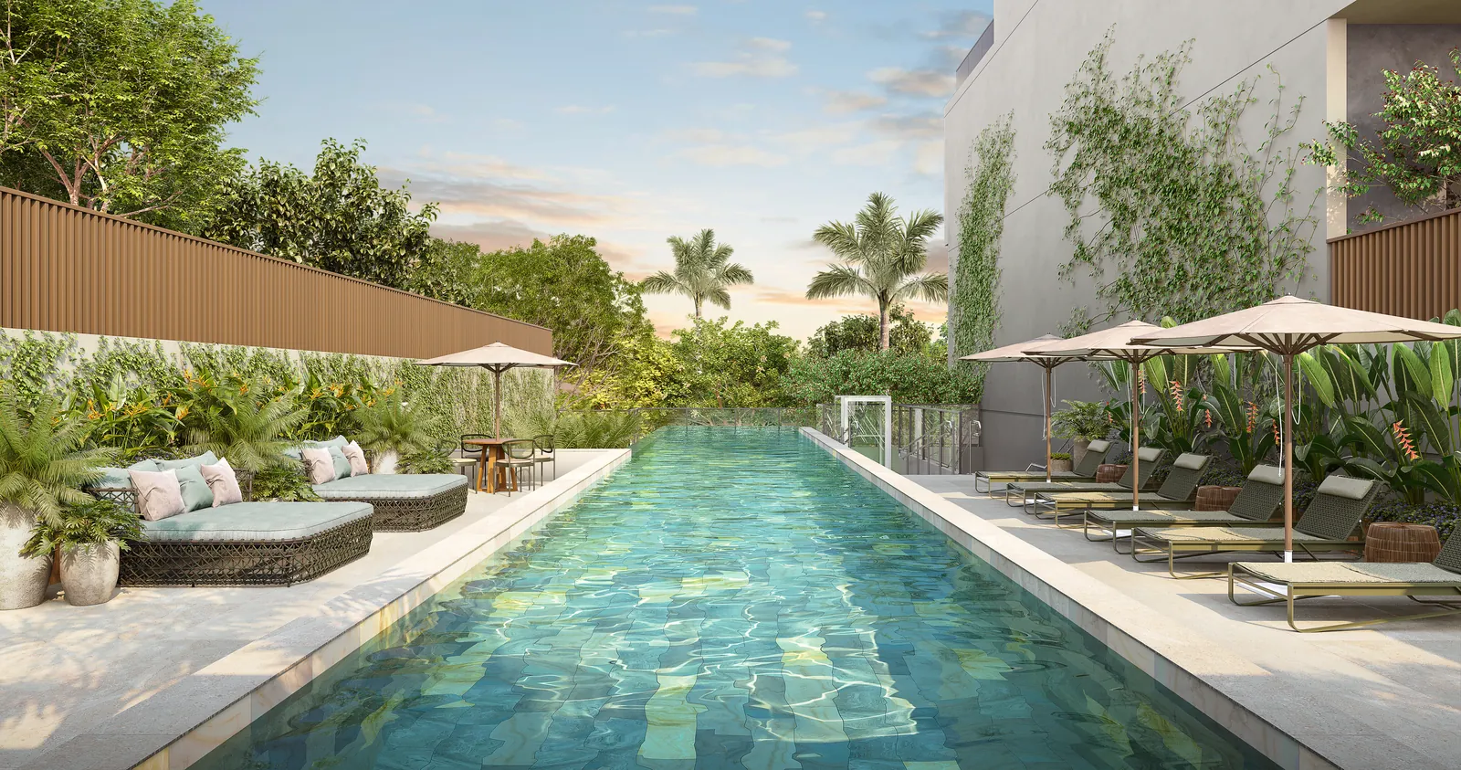 A piscina com raia de 25 metros, espreguiçadeiras e ombrelones entre a vegetação