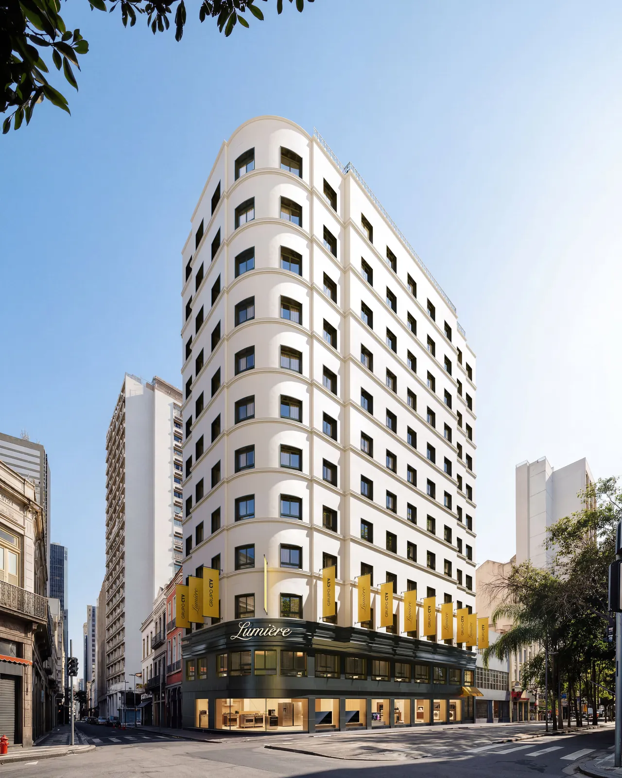 A fachada do Lumière, um prédio claro de esquina com a marquise amarela
