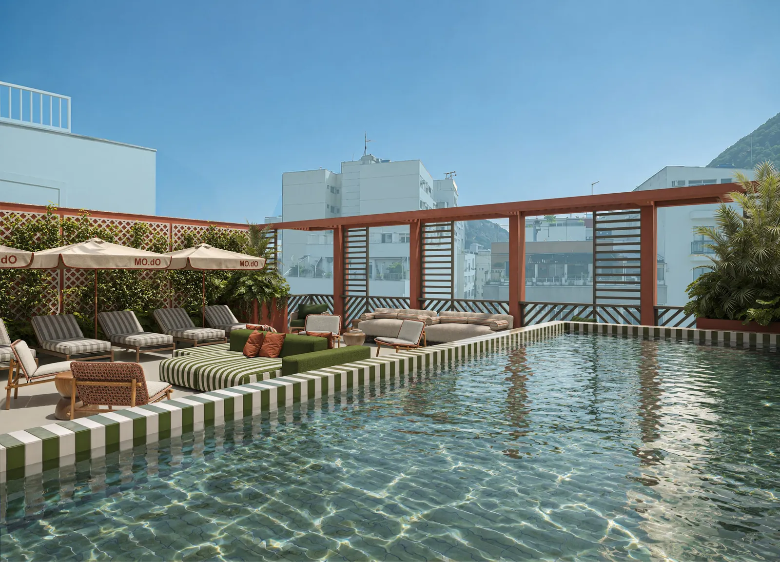 A piscina do rooftop com espreguiçadeiras listradas, guarda-sóis e pérgola terracota