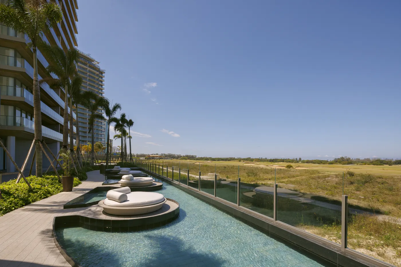 Foto real do Lounge Golf View, com piscina e espreguiçadeiras de frente para o golfe