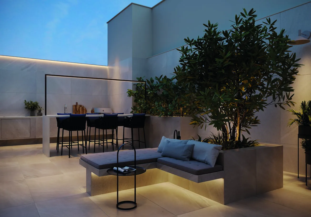 O terraço jardim do rooftop do Oui Ipanema, com árvore, sofás e mesa