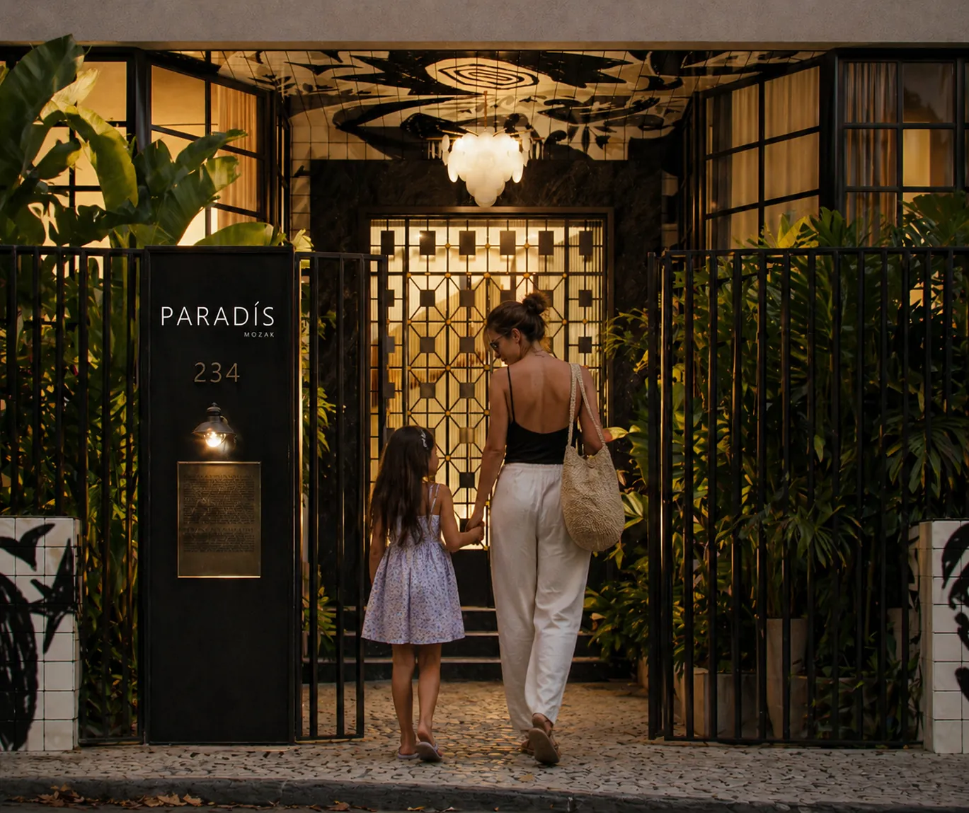Casal chegando à portaria do Paradís à noite, com gradil desenhado e lustre
